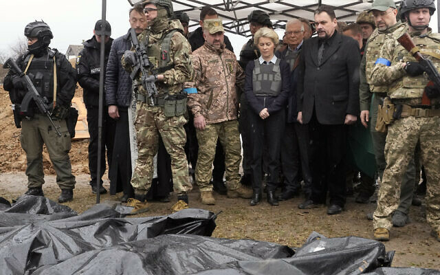 EU Commission President Ursula von der Leyen, center, looks at covered bodies of killed civilians in Bucha, on the outskirts of Kyiv, Ukraine, Friday, April 8, 2022. (AP Photo/Efrem Lukatsky)