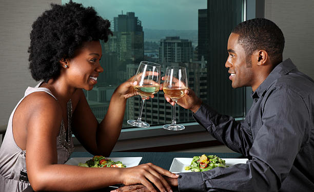 This is a photo of a young African American couple having a romantic dinner together. There are similar images of this couple in the lightbox below.