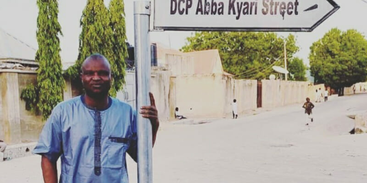 DCP Abba Kyari posing with Sign Post of the street named after him