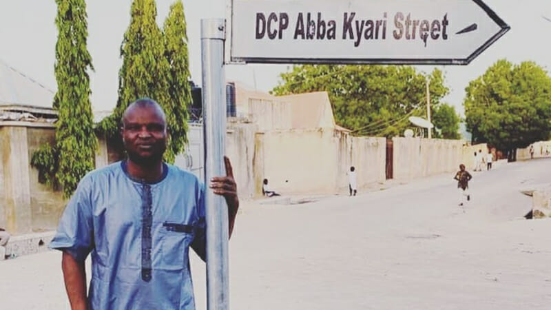 DCP Abba Kyari posing with Sign Post of the street named after him