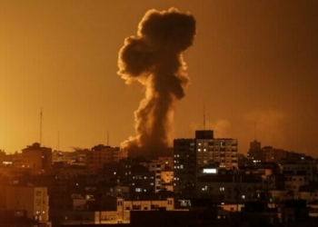 A picture taken on November 12, 2018, shows smoke rising above the building housing the Hamas-run television station al-Aqsa TV in the Gaza Strip during an Israeli air strike. - Israel's military said it was carrying out air strikes "throughout the Gaza Strip" after rocket fire from the Palestinian enclave towards its territory. (Photo by Mahmud Hams / AFP)