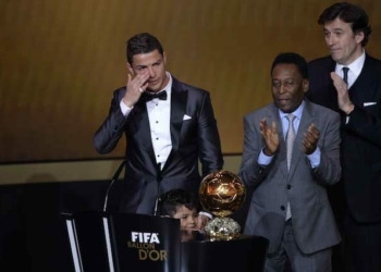 Brazilian football legend Pele (R) applauds next to Real Madrid's Portuguese forward Cristiano Ronaldo as he cries after receiving the 2013 FIFA Ballon d'Or award for player of the year during the FIFA Ballon d'Or award ceremony at the Kongresshaus in Zurich on January 13, 2014. AFP PHOTO / FABRICE COFFRINI