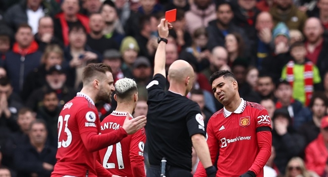 Manchester United's Brazilian midfielder Casemiro (R) reacts after being shown a red card by English referee Anthony Taylor during the English Premier League football match between Manchester United and Southampton at Old Trafford in Manchester, north-west England, on March 12, 2023. (Photo by Darren Staples / AFP) / RESTRICTED TO EDITORIAL USE. NO USE WITH UNAUTHORIZED AUDIO, VIDEO, DATA, FIXTURE LISTS, CLUB/LEAGUE LOGOS OR 'LIVE' SERVICES. ONLINE IN-MATCH USE LIMITED TO 120 IMAGES. AN ADDITIONAL 40 IMAGES MAY BE USED IN EXTRA TIME. NO VIDEO EMULATION. SOCIAL MEDIA IN-MATCH USE LIMITED TO 120 IMAGES. AN ADDITIONAL 40 IMAGES MAY BE USED IN EXTRA TIME. NO USE IN BETTING PUBLICATIONS, GAMES OR SINGLE CLUB/LEAGUE/PLAYER PUBLICATIONS. - RESTRICTED TO EDITORIAL USE. No use with unauthorized audio, video, data, fixture lists, club/league logos or 'live' services. Online in-match use limited to 120 images. An additional 40 images may be used in extra time. No video emulation. Social media in-match use limited to 120 images. An additional 40 images may be used in extra time. No use in betting publications, games or single club/league/player publications. /