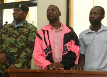 (FILES) Self-proclaimed pastor Paul Nthenge Mackenzie (C), who set up the Good News International Church in 2003 and is accused of inciting cult followers to starve to death "to meet Jesus", appears in the dock with other co-accused at the court in Malindi on May 2, 2023. - A Kenyan court on February 6, 2024 charged self-proclaimed pastor and cult leader Paul Nthenge Mackenzie and dozens of suspected accomplices with murder over the deaths of nearly 200 people. (Photo by SIMON MAINA / AFP)