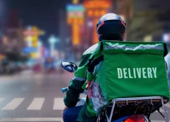 A delivery driver riding a motorcycle