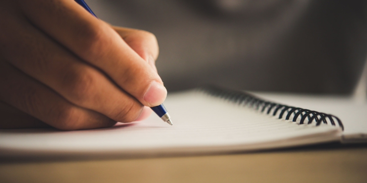 Man hand with pen writing on notebook.