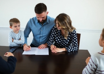 Couple signing prenup with children present