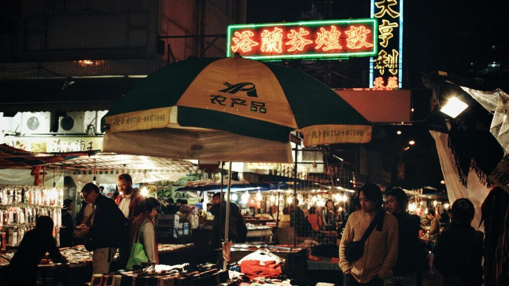 A group of people standing around a market at night