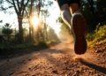 Runner's feet on a trail, sunlight through trees.