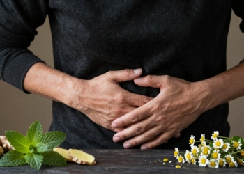 Person with stomach pain holding stomach, natural remedies