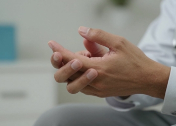 Hands with a slight tremor, Parkinson's disease symptom.