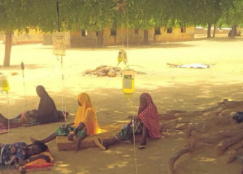 residents receiving drip under a tree
