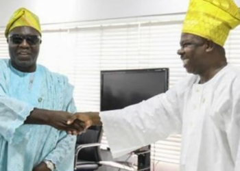 Visually impaired Akinyemi Andrew Elijah exchanging handshake with Governor Amosu