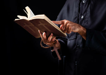 Pastor reads the Bible.The cross in the Pastor hand
