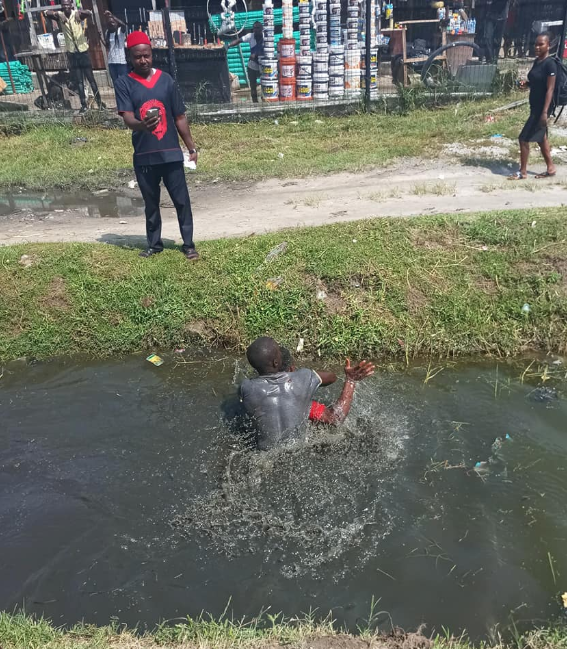 Bus driver and conductor fight inside gutter in Lekki over payment (photos)