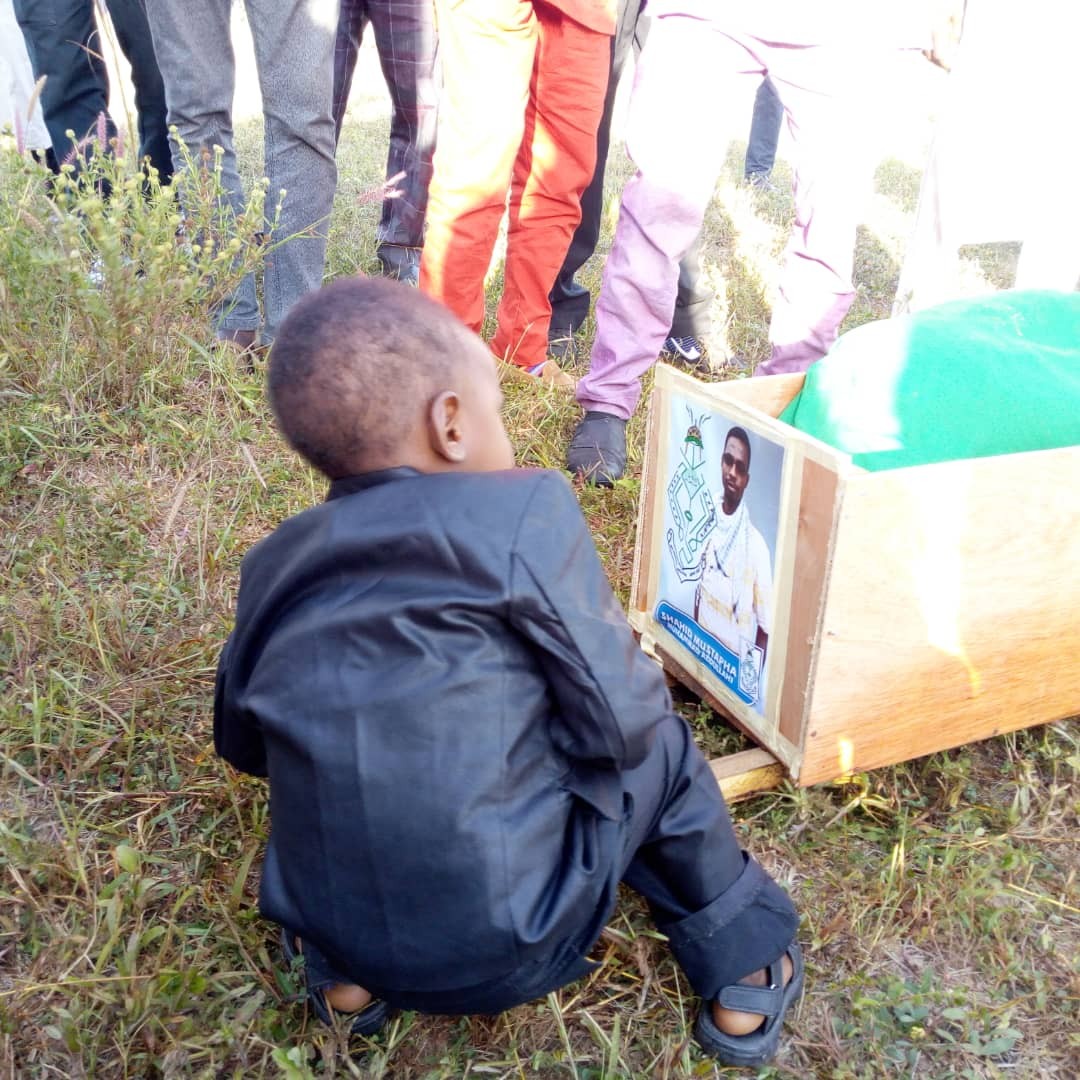 Heartbreaking photos of a little boy staring at the photo of his Dad killed during the Shiite/Security agents clash in Abuja