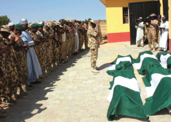 Some military men praying for the Metele fallen heroes before their burial, in Maiduguri on Friday