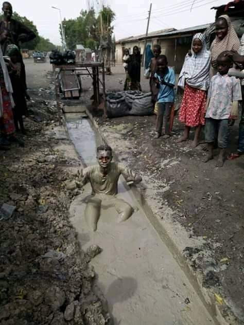 Another man dips himself inside dirty gutter to celebrate President Muhammadu Buhari