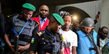 Naira Marley sandwiched between Police officers