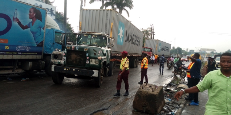LASTMA officials moving trucks parked on roadside along Iyana-Isolo road, Oshodi.