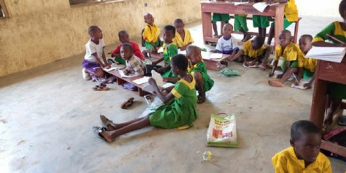 pupils sit on floor to learn