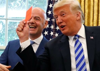 U.S. President Donald Trump holds up a red card as he meets with FIFA President Gianni Infantino in the Oval Office of the White House in Washington, U.S.