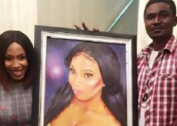 Mercy Eke receiving painting from an artist
