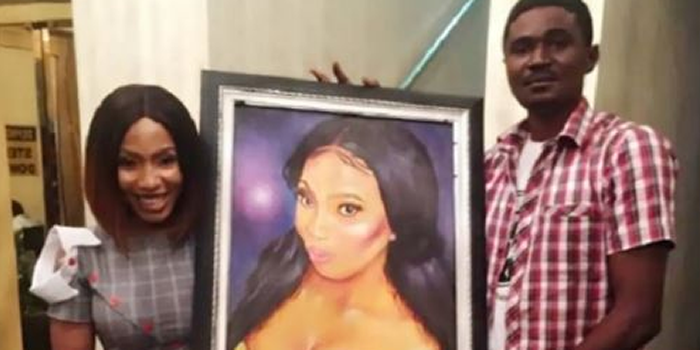 Mercy Eke receiving painting from an artist