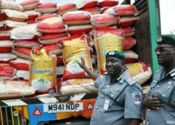 Depict of customs officials and seized bags of foreign rice