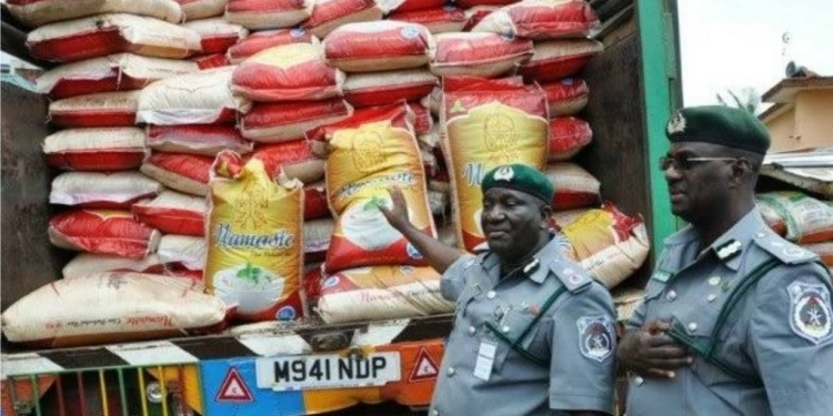 Depict of customs officials and seized bags of foreign rice