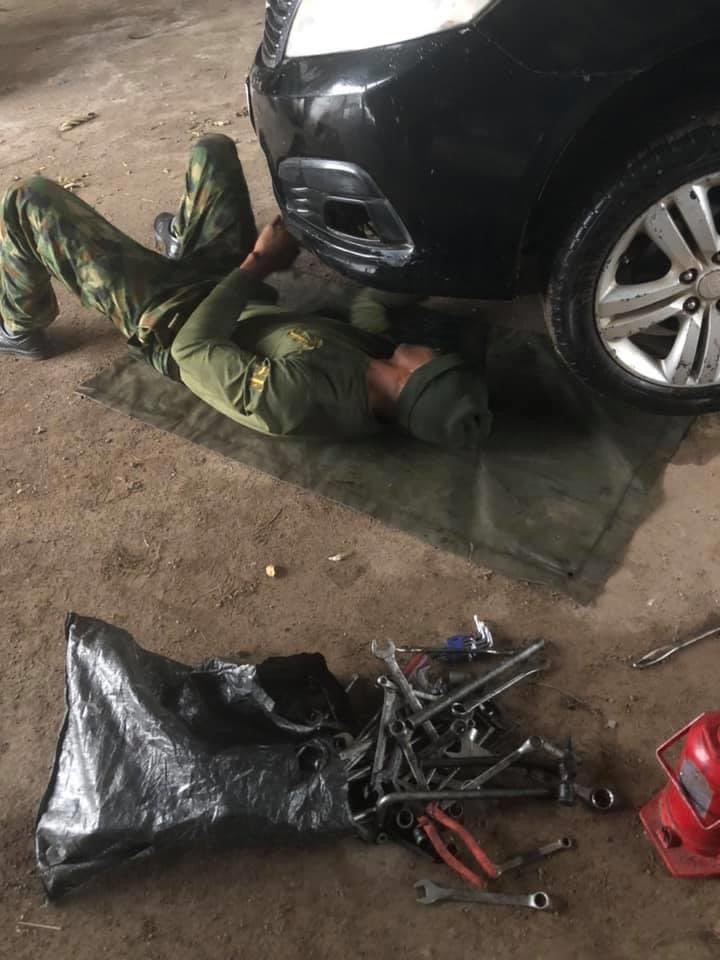 PHOTOS: Soldier appreciated by Nigerian man after helping him to repair his faulty car in the rain