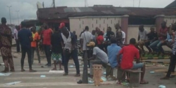 Youths cook with firewood in front of Shell company as they protest sacking of their kinsmen in Rivers