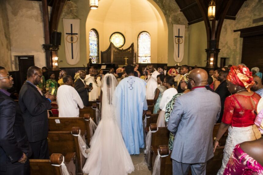 Nigerian couple standing before a pastor during a church wedding ceremony.